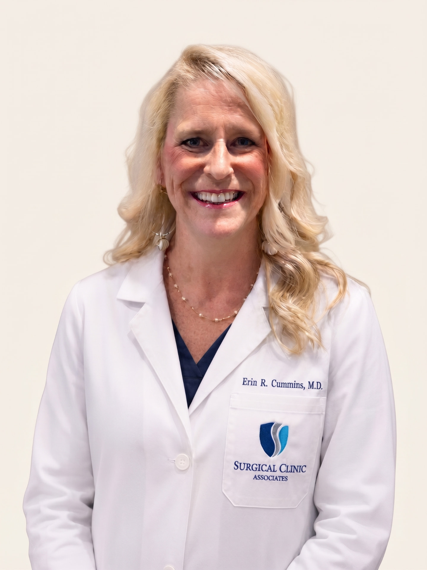 Portrait of Erin R. Cummins, MD, FACS, in a white coat
